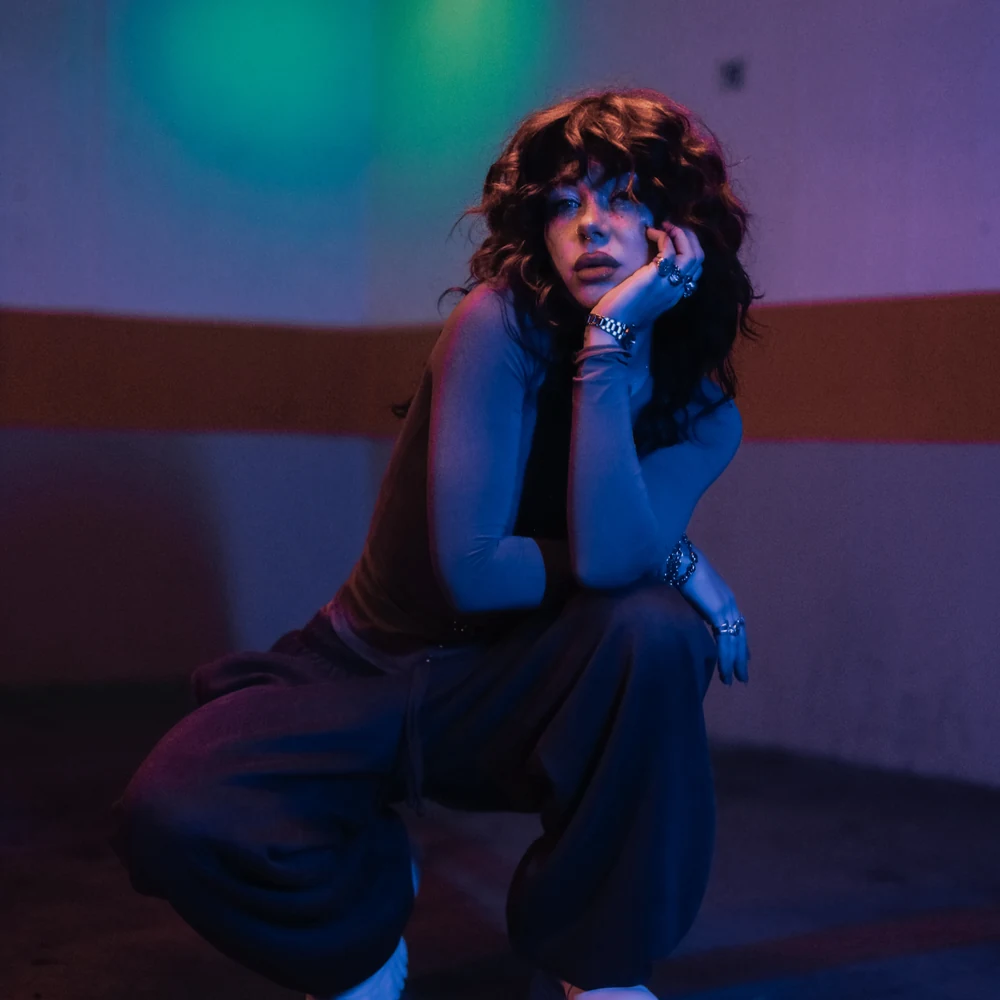 Anastasiya Ty seated in a blue and violet editorial portrait